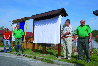 U ještě zahalené první tabule NS stojí v zelených tričkách stejnokroje třemošenských turistů vlevo Rudolf
Kule a vpravo Miroslav Dřízhal.
