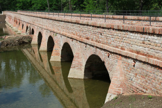 Teď bude nutné ještě upravit terén kolem mostu. Dle vizualizace má pod ním potok protékat úzkým korytem a zbytek vyplní zelená vlhká niva.