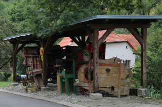 Ze zaprášené stodoly k hlavní cestě. Ihned naproti zvoničce zatraktivnily obec vysloužilé zemědělské stroje.