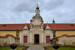 Hlavní jižní portál se štítovým nástavcem přestavěl v roce 1729 Kilián Ignác Dientzenhofer. Sochy sv. Sebestiána a Rocha pocházejí z roku 1710.