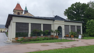 Oranžerie v Letohradu. Za budovou vyčnívá vížka kostela sv. Václava a přilehlá zvonice.