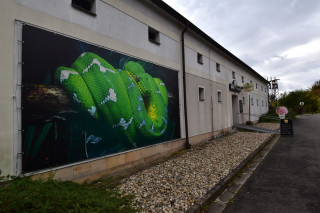 Už před vstupem do budovy lákají návštěvníky velkoformátové bannery.