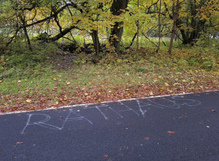 Zde byla radnice, oznamuje německé slovo „RATHAUS“ nasprejované na silnici.