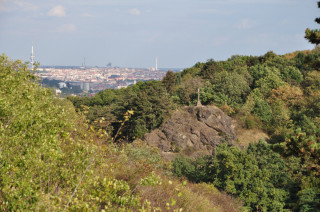 Pohled na kříž na kalvárii a netradiční pražské panorama z hřebenu severně nad Plzeňskou ulicí.